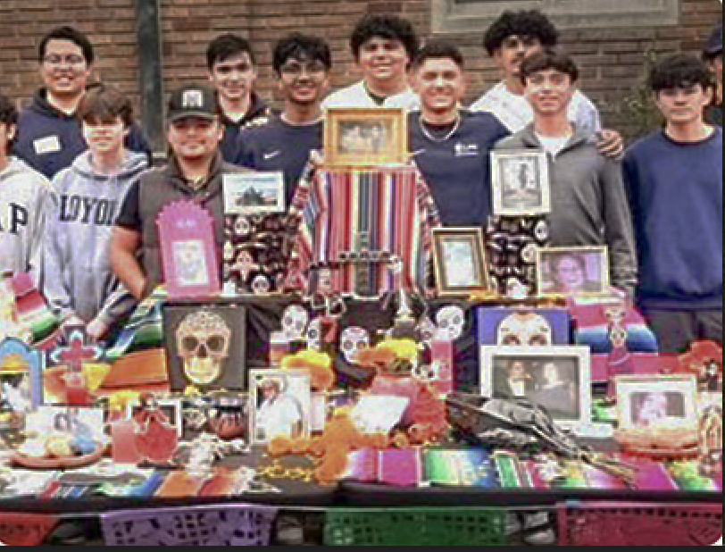 THE COMMUNITY GATHERS behind school ofrenda